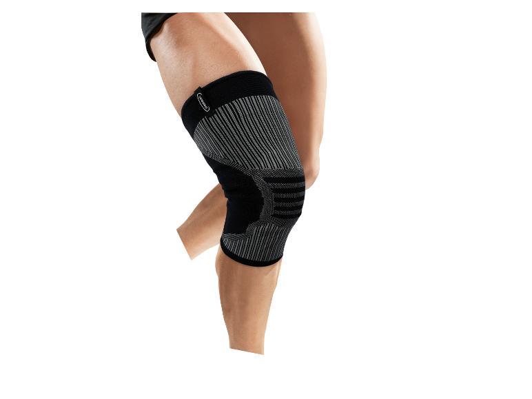 Genouillère de sport noire et grise sur une jambe