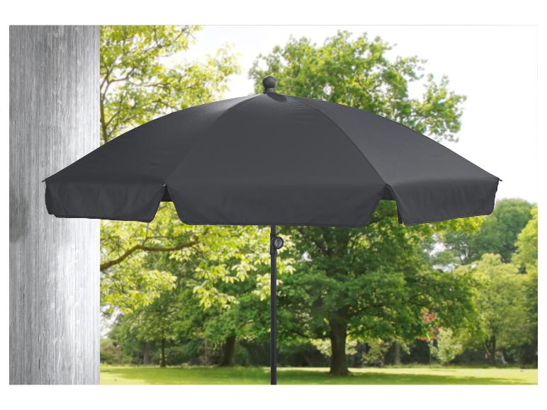 Un parasol noir dans un jardin vert.