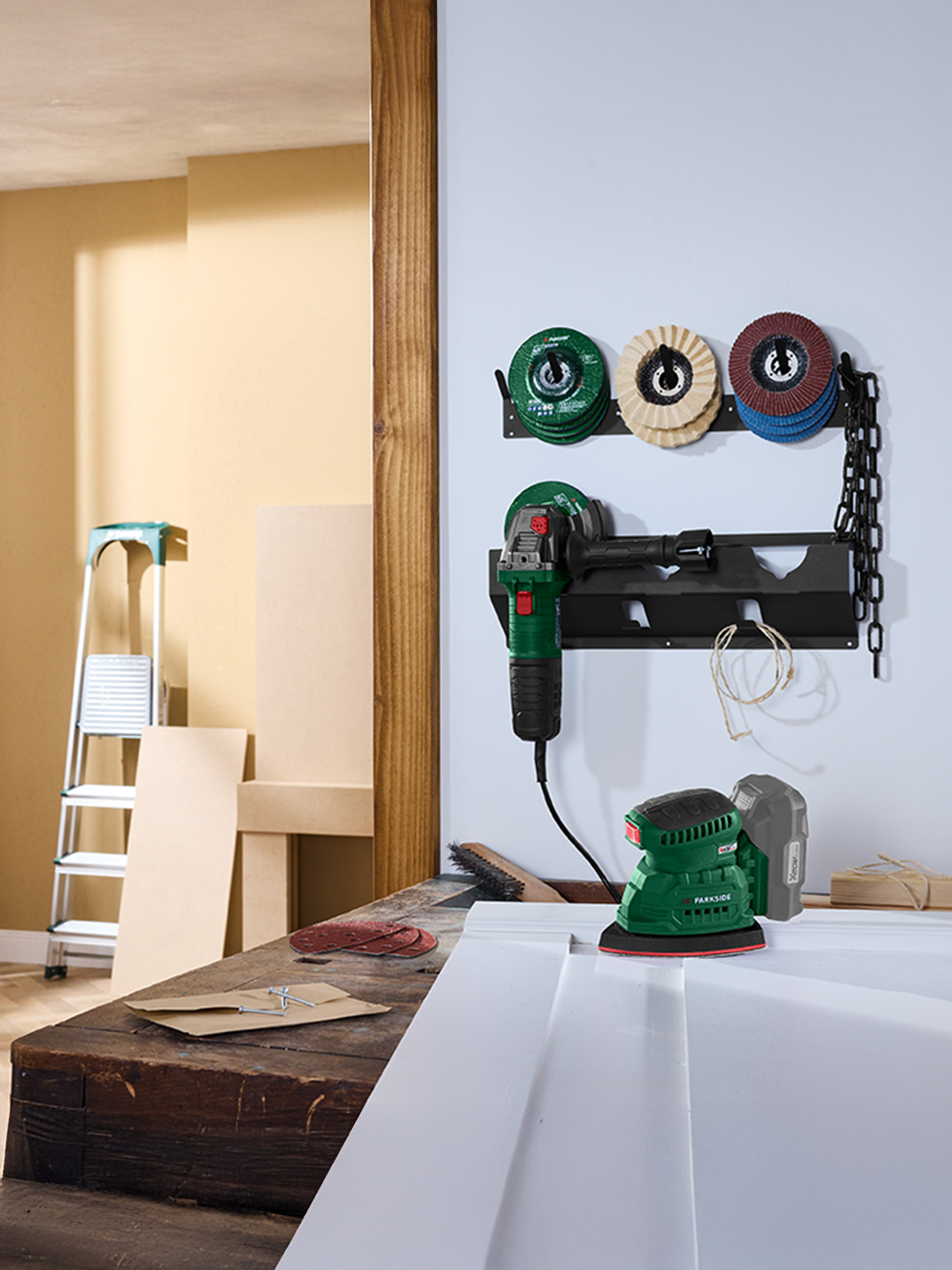 Une scène d'atelier avec une meuleuse et une ponceuse sur un établi, avec des disques de ponçage au mur.