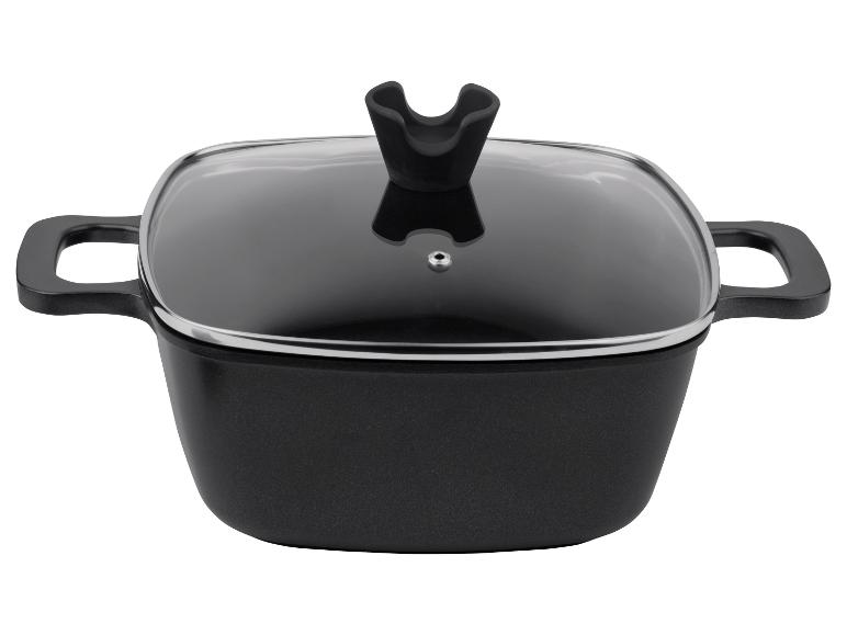Une casserole noire avec un couvercle en verre.