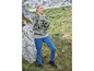Une femme portant un pull rayé et un jean bleu se tient dans un champ.