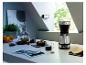 Cafetière avec tasse de café, biscuit et photos sur une table.