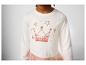 Un t-shirt blanc avec un imprimé de couronne rose et d'étoiles, avec une jupe en tulle rose.