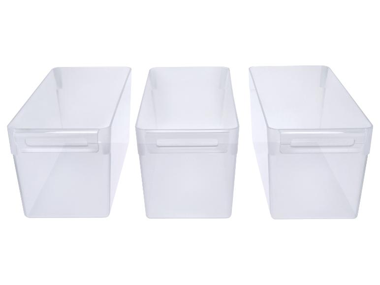 Trois bacs de rangement transparents avec poignées, alignés.