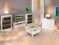 Bibliothèques blanches, meuble TV, table basse et commode à tiroirs dans un salon clair.