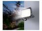 Projecteur LED extérieur avec détecteur de mouvement, illuminant un jardin.