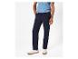 Un homme portant un pantalon bleu marine et des baskets blanches.