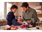 Père et fils fabriquent des fleurs en papier avec un pistolet à colle chaude.