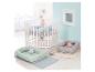 Lit bébé hexagonal blanc avec matelas bleu, deux nids bébé avec peluches et tapis.