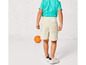 Un enfant porte un t-shirt bleu et un short blanc.