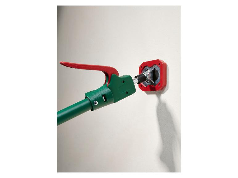 Outil vert et rouge s'engageant avec un raccord mural rouge.