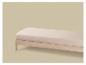 Un matelas beige clair sur un lit en bois sur fond beige.