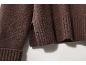 Gros plan d'un pull en maille marron avec ourlet côtelé et fente latérale