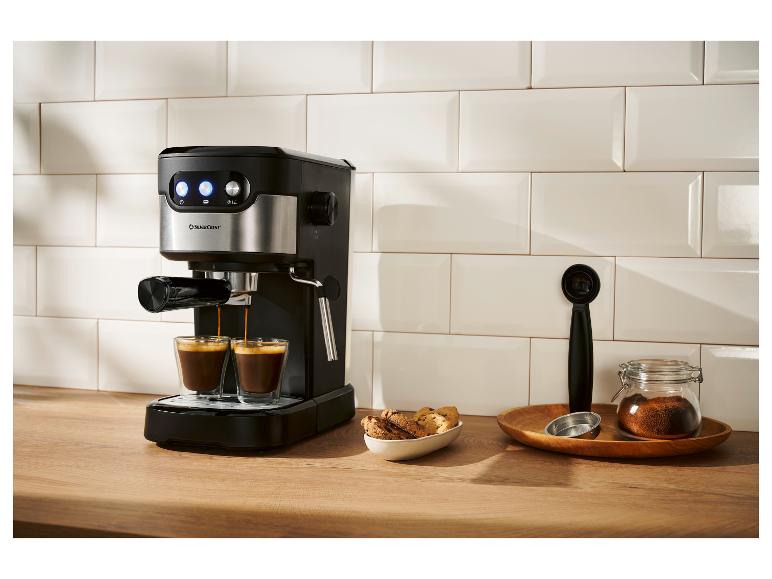 Machine à expresso noire et argentée préparant deux tasses de café dans une cuisine moderne.