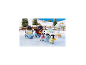 Jouets de famille de pingouins sur la glace avec un paysage hivernal en arrière-plan.