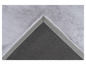 Détail d'un tapis en fourrure grise avec un envers gris foncé.