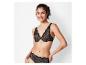 Une femme porte un soutien-gorge et une culotte en dentelle noirs.