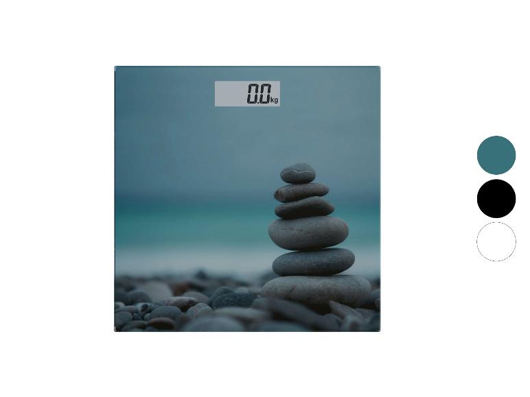 Pèse-personne avec une image de pierres empilées sur une plage et un affichage numérique de 0,0 kg.