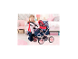 Fille avec poussette de poupée BAYER DESIGN Trendy Unicorn Cosatto dans une chambre d'enfant.
