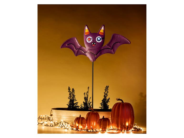 Décoration d'Halloween avec chauve-souris violette, citrouilles et lumières.