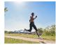 Femme courant en vêtements de sport et chaussures Puma sur un sentier dans le parc.