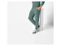 Un homme portant un pantalon de survêtement vert et des baskets blanches.
