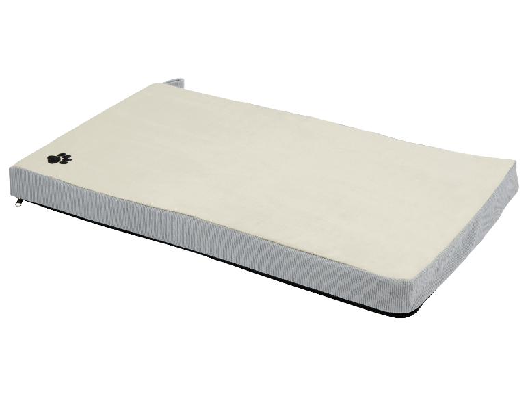 Un lit pour chien beige avec un bord gris.