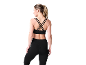 Femme de dos portant un soutien-gorge de sport noir à bretelles croisées et un legging assorti.