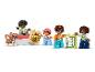 Figurines et briques LEGO Duplo avec un chat, des enfants et des objets du quotidien.