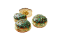 Beignets fourrés à la pistache avec chocolat et glaçage vert, un coupé.