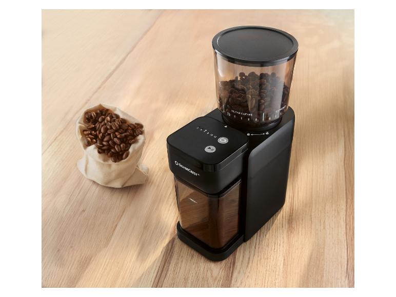 Moulin à café noir SILVERCREST avec un récipient à grains transparent et un sac de grains de café.