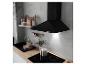 Cuisine moderne avec hotte noire, plaque à induction et évier, murs en béton et accents en bois.