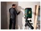 Un niveau laser Parkside sur un trépied, utilisé pour projeter une ligne sur un mur.
