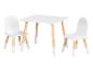 Une table blanche et deux chaises avec des pieds en bois pour enfants.