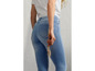 Une femme portant une chemise blanche et un jean bleu.