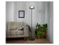Un lampadaire noir avec un abat-jour rond en verre dans un intérieur moderne.