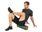 Homme avec un t-shirt Adidas assis sur un rouleau en mousse