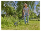 Une femme utilise une débroussailleuse électrique Gardena pour entretenir son jardin.