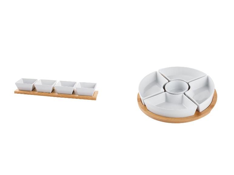 Un plat de service rond et rectangulaire en porcelaine blanche avec une base en bois.