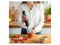 Femme dans la cuisine préparant une soupe de tomates avec un mixeur plongeant.