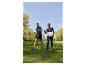 Deux personnes font de la marche nordique dans un parc.