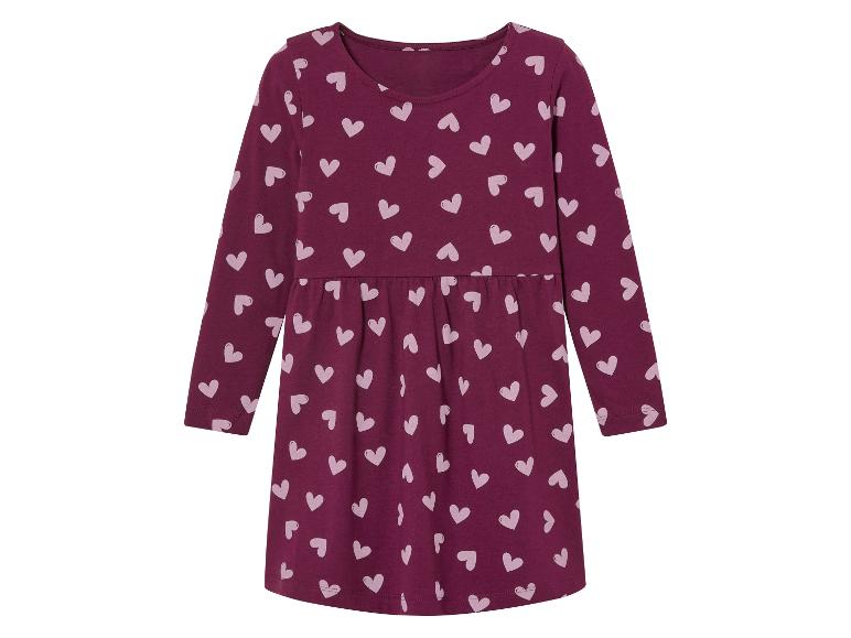 Une robe rose à manches longues avec un imprimé de cœurs roses.