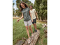 Une femme et un homme en short et sandales marchent sur une souche d'arbre.