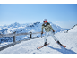 Skieur en veste de ski, pantalon de ski, casque et lunettes sur la montagne.