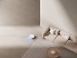 Robot aspirateur blanc nettoyant un salon moderne avec un canapé et un tapis beiges
