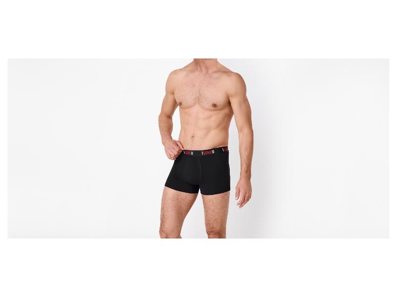 Homme torse nu en caleçon noir avec l'inscription 'I LOVE U' sur la ceinture.