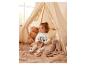 Une fille en pyjama Mickey Mouse joue avec des blocs dans un tipi.