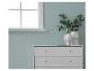 Commode blanche avec deux vases et des branches d'eucalyptus à côté d'une fenêtre.