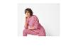 Une femme portant un sweat-shirt rose et un pantalon.