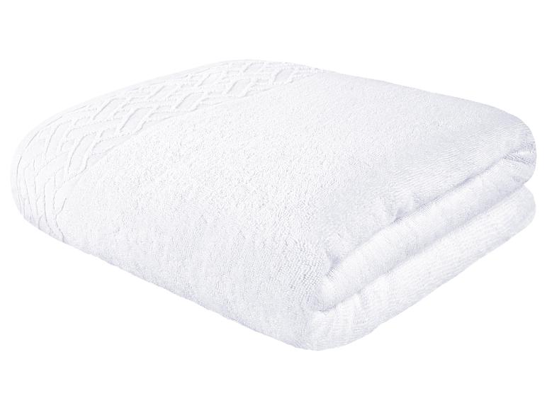 Une serviette de bain blanche avec un motif en relief.